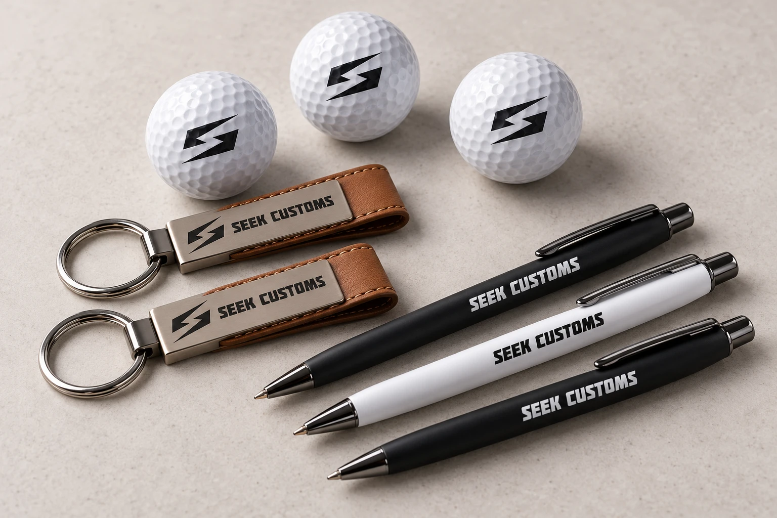 Seek Customs branded golf balls, leather keychains, and pens